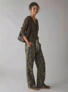 Full body view of a woman wearing camouflage cargo pants with a loose street style fit.
