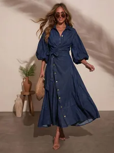 Detailed view of dark blue denim wrap dress with lantern sleeves and tie waist