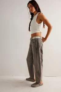 Side profile view of women's loose barrel-leg denim jeans in a vintage washed brown finish.
