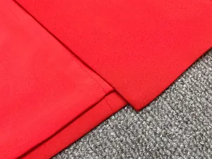 Détail rapproché du tissu rouge et des coutures d'une robe blazer pour femme chic