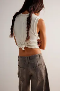 Back view of loose mid-waist barrel-shaped ladies jeans in grey-brown