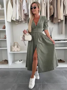 Fashionable V-neck long button-down denim dress in sage green shown in a closet setting