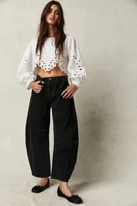 Full body shot of women wearing casual black loose barrel jeans and white cropped blouse
