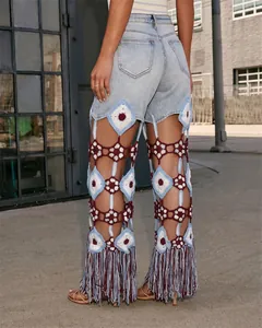 Pantalones vaqueros bohemios con intrincados patrones de ganchillo y flecos largos