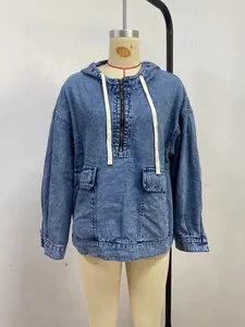 Vue rapprochée d'un sweat à capuche en denim bleu délavé avec demi-zip et poches avant