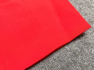 Gros plan sur le tissu rouge vif et les détails de couture du vêtement de luxe