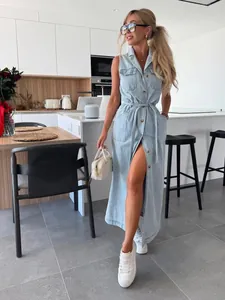 Mannequin portant une robe longue en jean sans manches avec ceinture dans un décor de cuisine