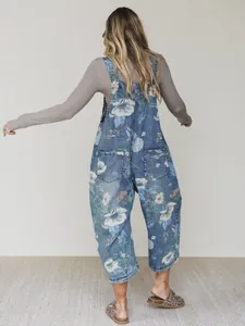 Back view of blue floral print denim wide-leg overalls with functional back pockets