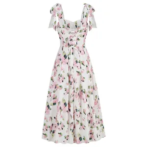 White midi dress with pink floral print, shoulder ties, and lace-up back detail