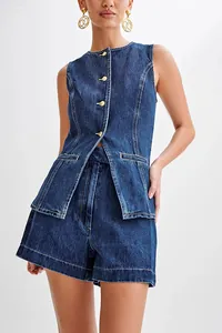 Detail view of sleeveless denim vest and high-waisted shorts with decorative gold buttons