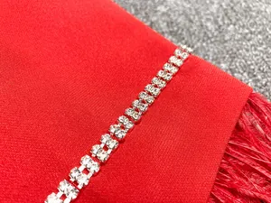 Gros plan sur les doubles rangées de strass et les bordures en plumes rouges élégantes