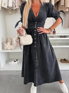 Full front view of a button-down denim dress with V-neckline and decorative sleeve ties.