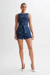 Professional shot of a female model in a stylish sleeveless denim vest and shorts set