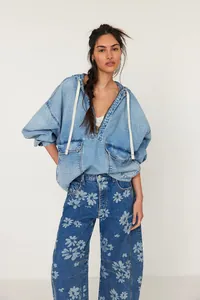 Détail d'un jean décontracté pour femme à coupe large et motif floral avec taille haute