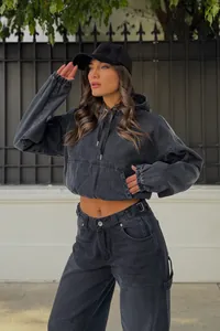 Sudadera corta con capucha en denim negro lavado lucida por una modelo en exterior