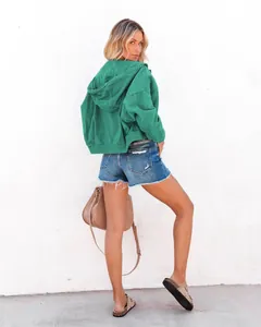 Rückansicht-Detail zeigt die Passform einer grünen Jeansjacke mit Kapuze am Model