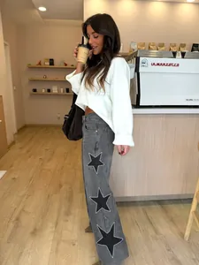 Fashionable loose straight grey jeans featuring decorative rhinestone star patterns