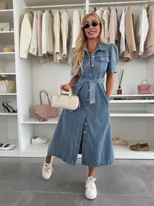 Detail view of a blue denim mid-length dress featuring a lapel collar and waist tie.