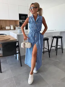 Mannequin portant une longue robe en jean sans manches dans une cuisine minimaliste chic.
