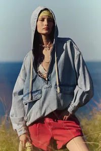Mannequin en sweat à capuche en jean délavé pour l'automne, ambiance décontractée plein air.