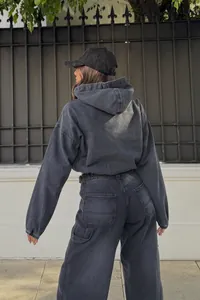 Vista trasera de una sudadera con capucha de denim negro lavado suelta y casual