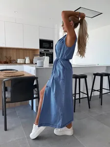 Femme portant une longue robe en jean sans manches avec ceinture dans une cuisine moderne.