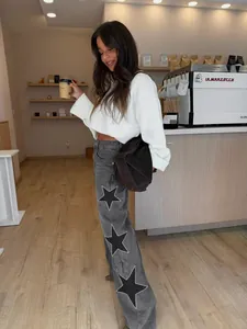 Detail view of stylish grey wide-leg denim jeans with unique decorative star patterns