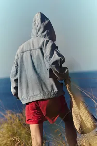Vue arrière d'une veste en jean à capuche décontractée et ample en denim bleu clair lavé