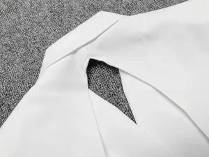 Gros plan détaillé de l'élégante découpe dos nu sur une robe blazer blanche de qualité