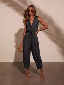 Casual dark wash sleeveless denim jumpsuit with drawstring waist and collar detail.