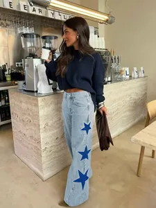 Lifestyle view of women's loose straight-leg jeans with blue star patterns