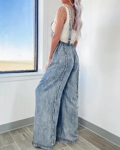 Detail view of retro washed denim wide-leg overalls with white frayed side seam accents.