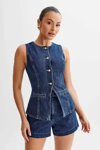 Close-up of model wearing sleeveless denim top and high-waisted shorts set