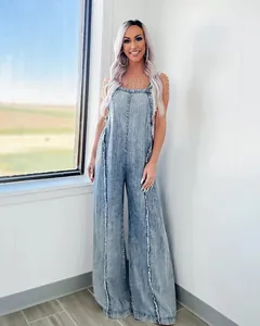 Vintage acid-wash wide-leg denim jumpsuit with frayed edges worn by a model