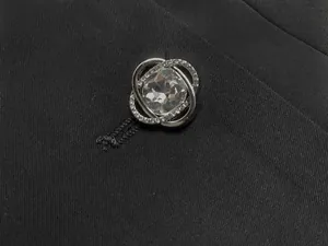 Détail macro d'un bouton de luxe en strass argentés sur un blazer noir