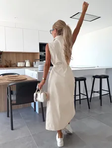 Vue arrière d'une femme portant une robe longue en jean sans manches avec ceinture