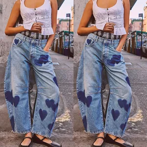 Women's light wash barrel jeans featuring dark denim heart patch details in an urban setting