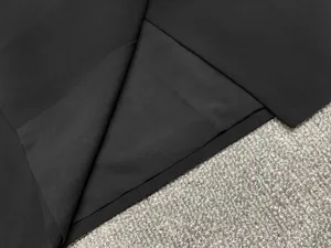 Vue macro d'un tissu noir de haute qualité et de la doublure d'une robe blazer