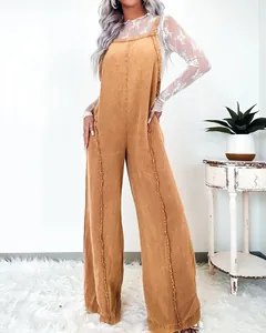 Close-up detail of vintage washed mustard yellow wide-leg overalls with decorative frayed edge stitching