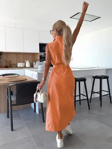 Vue de dos d'une robe longue en jean orange sans manches avec ceinture dans une cuisine