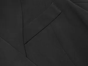 Vue macro montrant la texture du tissu tissé de haute qualité de cette robe blazer noire