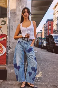 Street style photography of women's relaxed wide-leg denim jeans with navy blue heart patterns