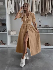 Fashion detail of a khaki V-neck maxi denim dress featuring button-down front design