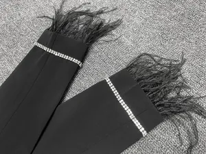 Détail de poignets de blazer noir de luxe avec plumes d'autruche et strass étincelants