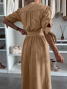 Back view of a khaki denim maxi dress with tie-sleeve details in a closet setting