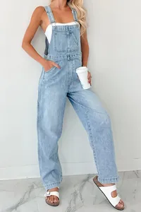 Detail view of light wash blue denim overalls with cargo pockets and adjustable buckles