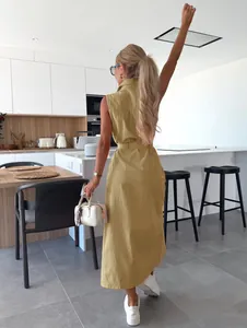 La vue arrière d'une robe longue sans manches en jean jaune moutarde avec ceinture