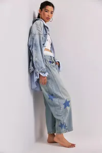 Full body shot of women's wide-leg jeans with blue star prints on light denim wash
