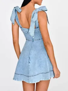 Back view of a light blue denim mini dress featuring stylish bow-tie shoulder straps
