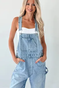 Close-up detail of stylish light blue denim overalls paired with a white tube top